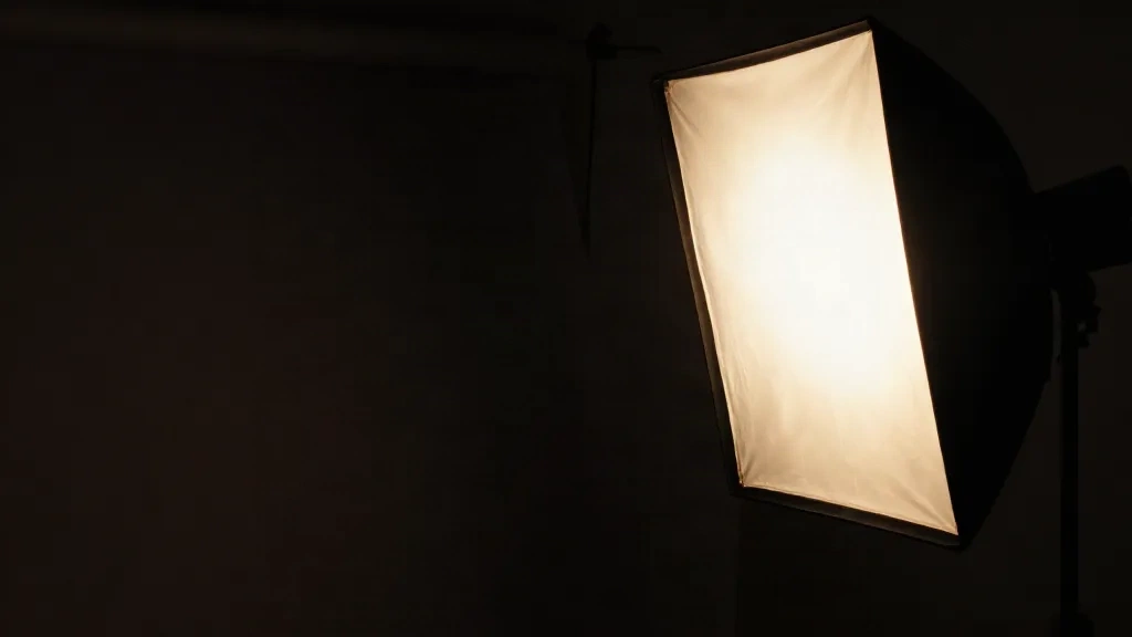 A softbox glowing in the dark studio